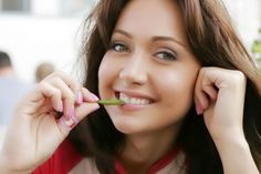 a woman is smiling while she brushes her teeth