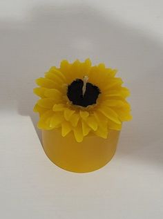 a yellow vase with a sunflower in it