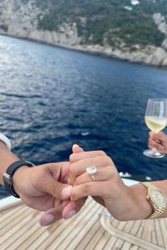 two people holding hands while on a boat