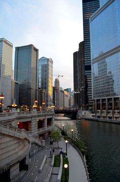 the city is full of tall buildings and skyscrapers, along with a river running through it