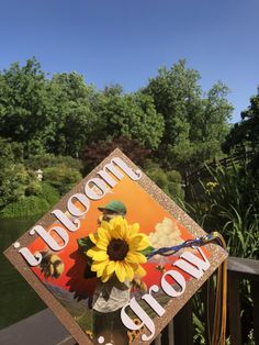 a decorated graduation cap with a sunflower on the front and words welcome to me