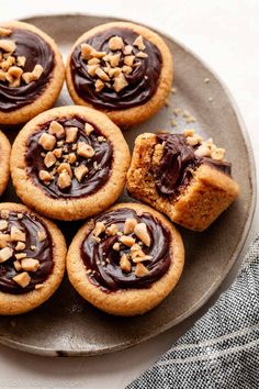 several cookies with chocolate frosting and walnuts on a plate