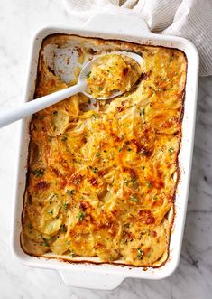 a casserole dish with chicken and cheese in it on a marble countertop