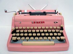 an old fashioned pink typewriter with keys and numbers on the front, against a white background