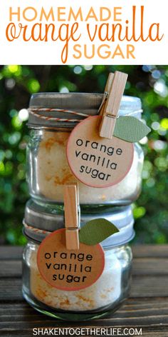 three jars filled with orange vanilla sugar sitting on top of a wooden table next to each other