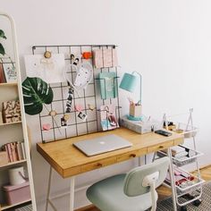 a wooden desk topped with a laptop computer next to a book shelf filled with books