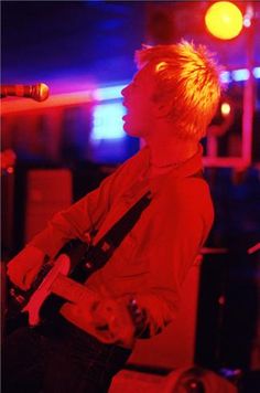 a young man playing an electric guitar on stage