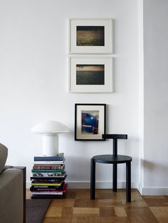 a living room with white walls and pictures on the wall above it's chair