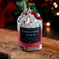 a small glass cup filled with whipped cream and sprinkles on top of a wooden table