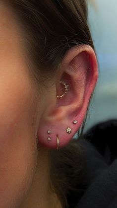 a close up of a person's ear with small gold stars on the side