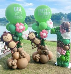 three monkey balloons are sitting on the ground with one balloon in the shape of an number