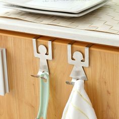 two towel hooks are attached to a wooden cabinet