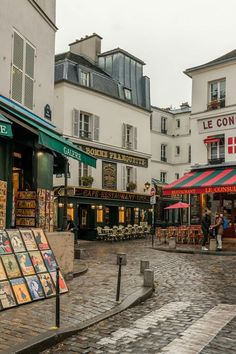 an outdoor market with tables and umbrellas on a rainy day in the french city