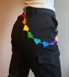 a person wearing black pants with colorful beads on them