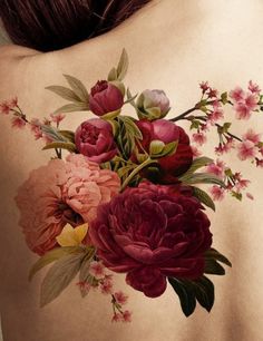 the back of a woman's body with flowers painted on her chest and shoulder