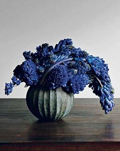 blue flowers in a vase on a wooden table