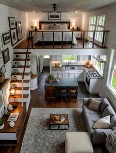 a living room and kitchen with stairs leading up to the loft bed in this modern home