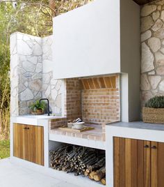 an outdoor kitchen with wood and brick on the outside, including a stove top oven