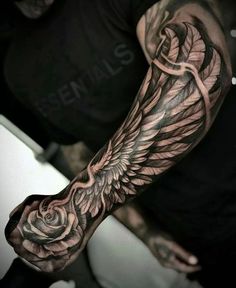 a man with a tattoo on his arm holding a rose and an angel's wing