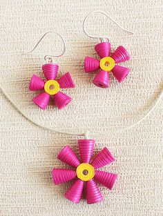 two pink and yellow pinwheel earrings on a white surface