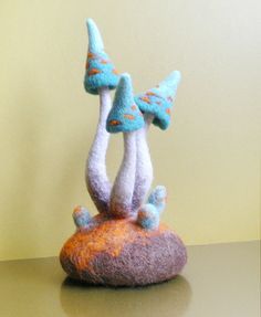 two felt mushrooms sitting on top of a rock