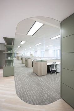 an empty office cubicle with desks and chairs