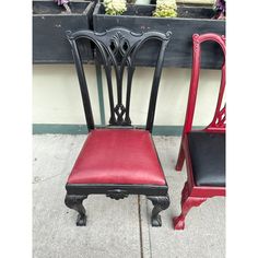 two red and black chairs sitting next to each other on the side of a building