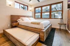 a bed sitting in the middle of a bedroom next to a window with lots of windows