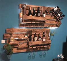 two wooden wine racks holding bottles and glasses on the wall in a room with blue walls