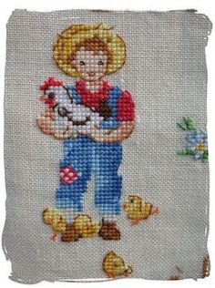 a cross stitch picture of a little boy holding a dog and chickens in his hands