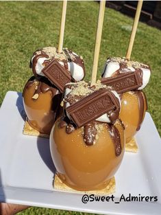 four caramel apples with chocolate and marshmallows in them on a white plate