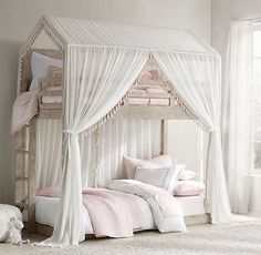 a white canopy bed with pink sheets and pillows in a girls'bedroom, next to a window