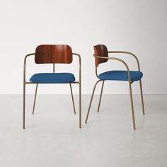 two chairs with blue upholstered cushions and wooden arms, one in the shape of a chair