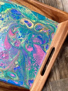 a wooden tray with an abstract painting on it