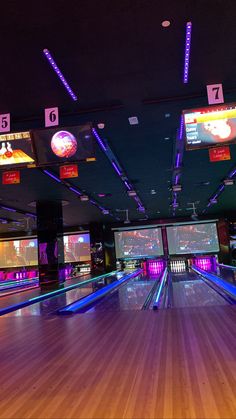 bowling alley with neon lights and large screen tvs