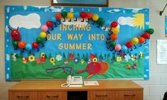 a bulletin board with the words, including our way into summer written on it in front of a classroom desk