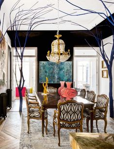 the dining room is decorated in black, white and gold with an elegant chandelier hanging from the ceiling