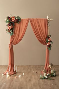 an arch decorated with flowers and candles for a wedding or ceremony setting in the middle of a wooden floor