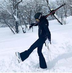 a person walking in the snow with skis on their shoulders