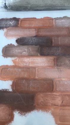 several different shades of brown paint on a white surface