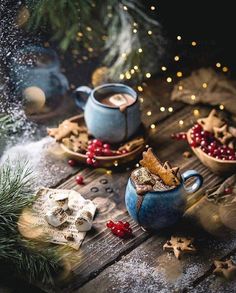 two blue mugs filled with hot chocolate and cranberries