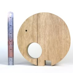 an elephant shaped wooden toy next to a ruler