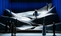 a group of people standing on top of a stage next to a giant piece of art