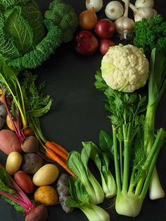 there are many different types of vegetables arranged in a circle on the black table top