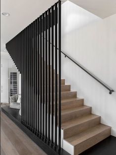 an iphone photo of a stair case in a house with white walls and wood floors