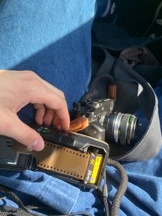 a person holding a camera in their lap and taking pictures with the other hand on it