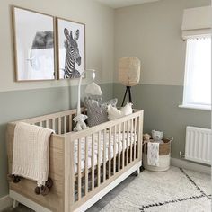 a baby's room with two pictures on the wall and a crib next to it