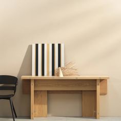 a wooden table with a black chair next to it and a painting on the wall