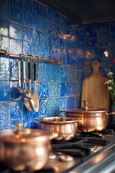 pots and pans are sitting on the stove in this kitchen with blue tiled walls