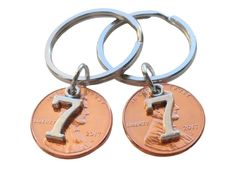 two penny key chains with the number seven on them